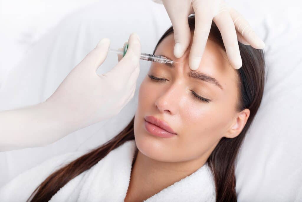 young woman receiving botox injection in forehead